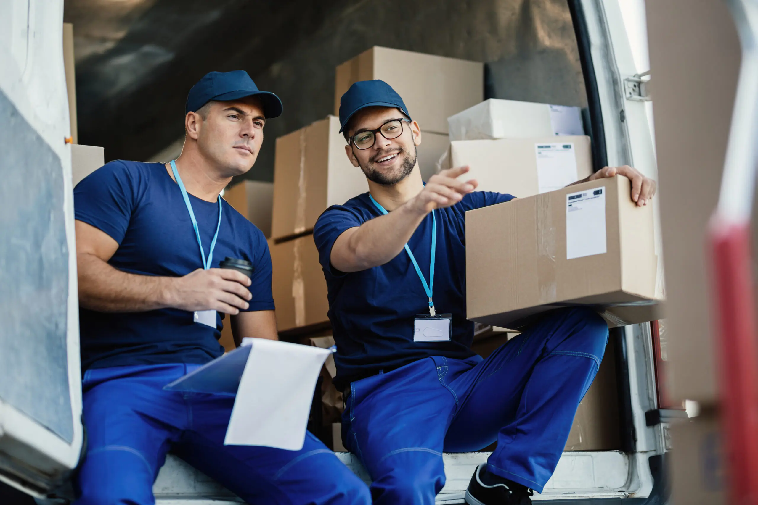 Movers discussing a job beside a moving van